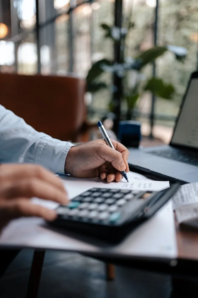 man crunching the numbers on his calculator during tax season