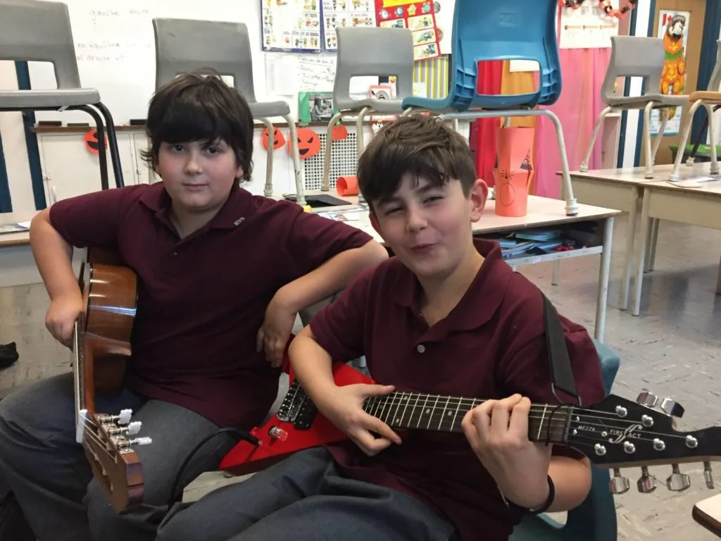 Lucas and Jonathan learning guitar